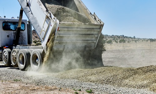 Aggregate truck moving material at a work site